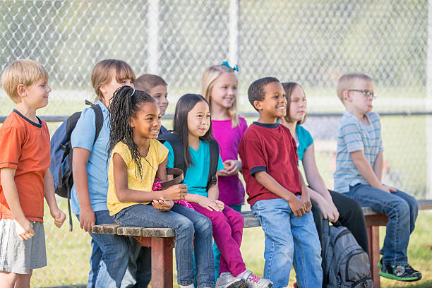 istock School Children Sitting Outside 504453514