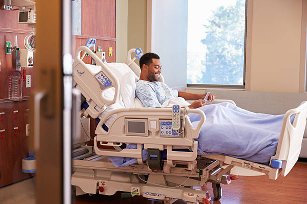 istock Male Patient In Hospital Bed Using Cellphone 504459672