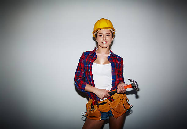 Young female in helmet holding hammer