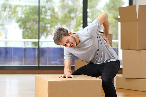 hombre con dolor de espalda moviendo cajas - dorsal lumbar fotografías e imágenes de stock