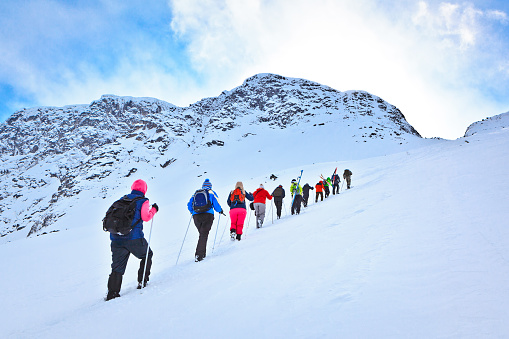 Murmansk region, Russia - April 08, 2013: group of tourists climbing to the mountain pass during their ski hike in the beautiful but harsh mountains of the Arctic, Hibiny