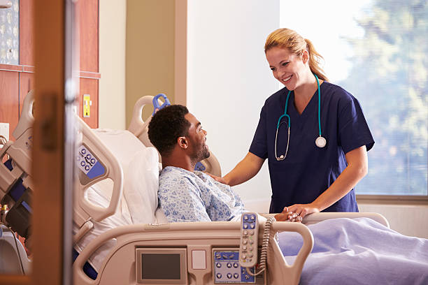 Female Doctor Talking To Male Patient In Hospital Bed Female Doctor Talking To Male Patient In Hospital Bed hospital patient bed nurse stock pictures, royalty-free photos & images