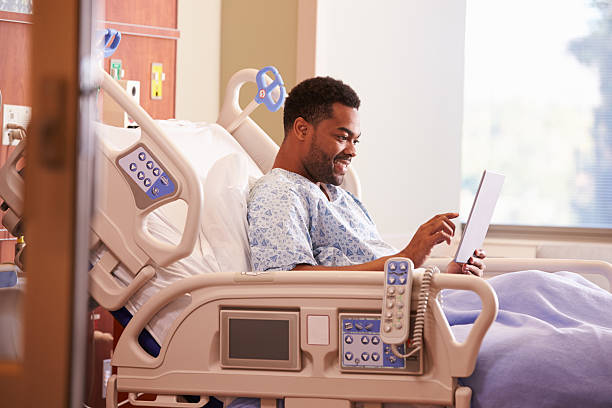 paciente de sexo masculino en la cama de hospital usando tableta digital - patient room fotografías e imágenes de stock