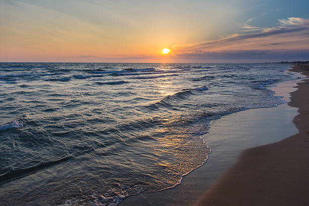 istock Sunset over beach sea tide sand coast seashore 504477918