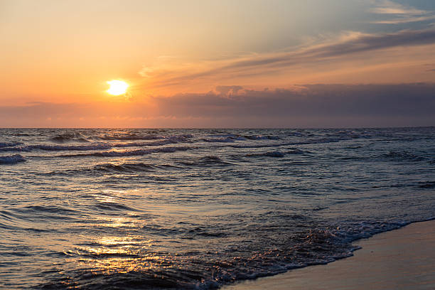 istock Sunset over beach sea tide sand coast seashore 504477972