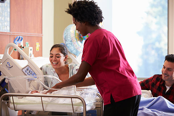 Family With New Born Baby In Post Natal Department Family And Nurse With New Born Baby In Post Natal Department maternity ward stock pictures, royalty-free photos & images