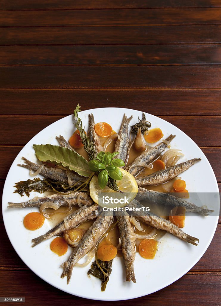 Marinated sardines with Mediterranean herbs Tasty Marinated sardines on white plate with Mediterranean herbs , space for text Anchovy Stock Photo