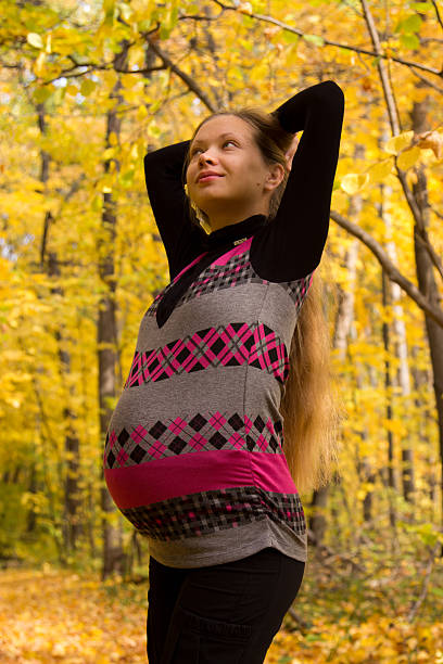 Walk in golden autumn forest expectant mother Walk in golden autumn forest expectant mother, a woman in the ninth month of pregnancy 8 months pregnant stock pictures, royalty-free photos & images
