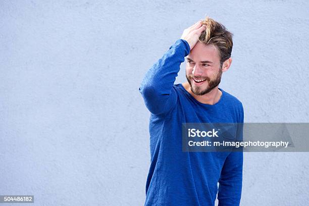 Male Fashion Model Smiling With Hand In Hair Stock Photo - Download Image Now - Men, Only Men, Hand In Hair