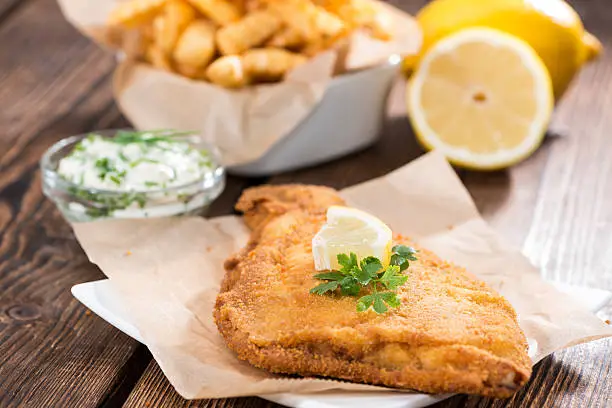 Fried Plaice with Chips and homemade remoulade on wooden background