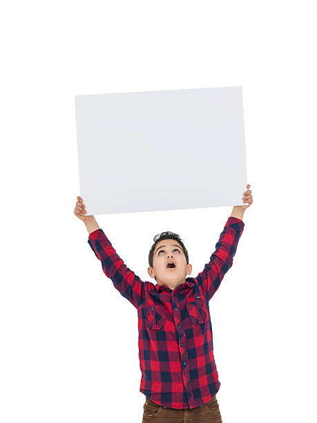 istock Little boy holding placad above his head 504487964