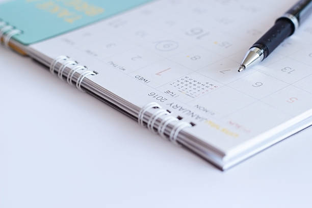 istock sheet of a calendar and a pen on white background 504487986