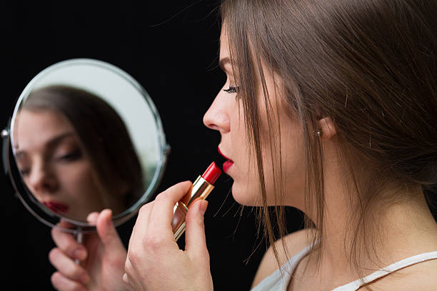 istock Woman with a mirror and a red lipstick 504488956