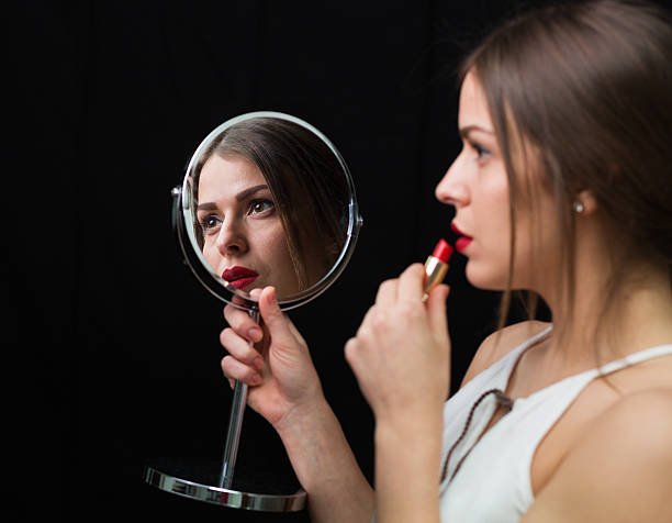 istock Woman with a mirror and a red lipstick 504489074