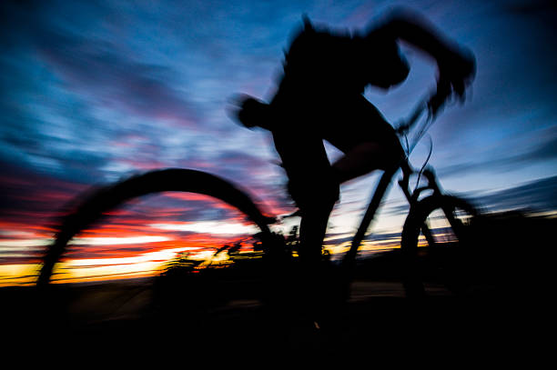 Silhouette of cyclist on sunset background.