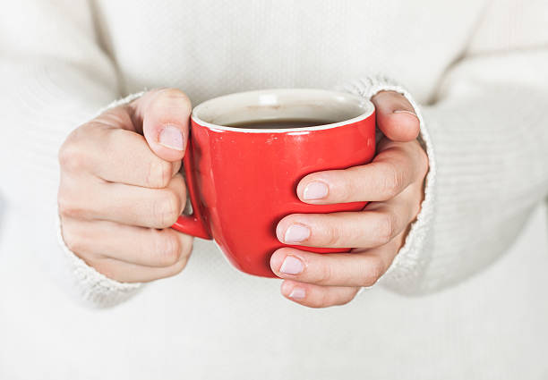 istock Cup of tea or coffee in female hands 504492470
