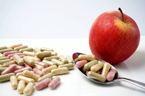 istock Medicine capsule vs healthy apple 504507589