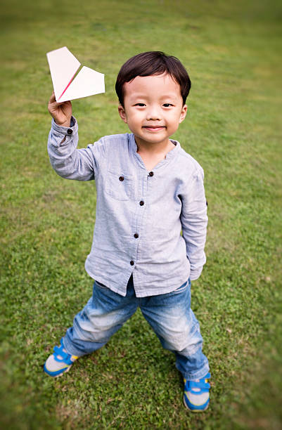 istock Boy with paper airplane 504508315