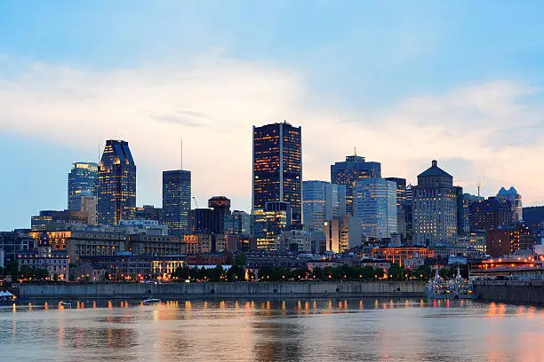 Montreal over river at sunset with city lights and urban buildings