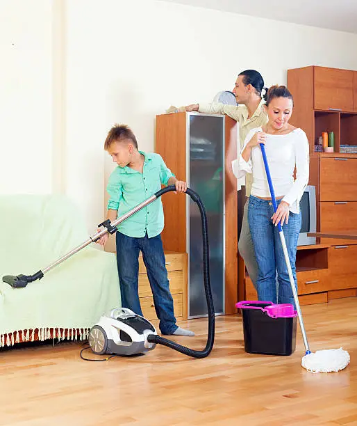 Ordinary family doing  cleaning with  cleaning equipment in living room