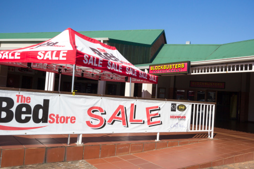 Hillcrest, South Africa - May 19, 2014: A bed sale at the Hillcrest Heritage Centre outside Durban. Towards the back is a Blockbusters video for hire shop.