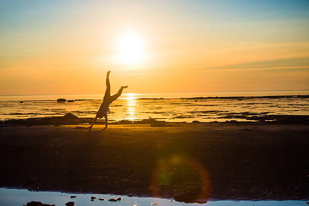 istock man cartwheeling at the beach. 504511517