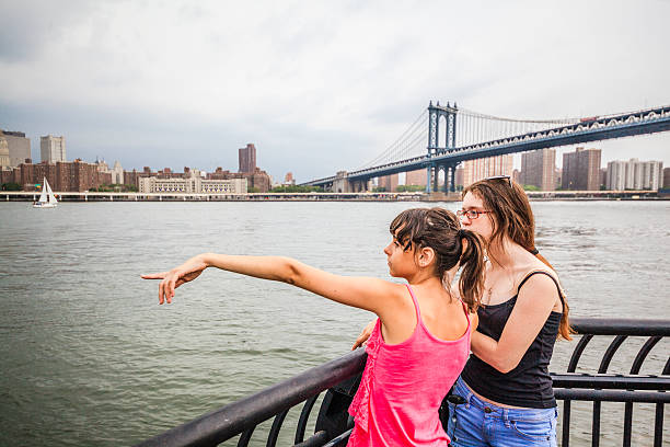 istock Two girls, sisters, looking to Manhattan under thunderstorm 504511591