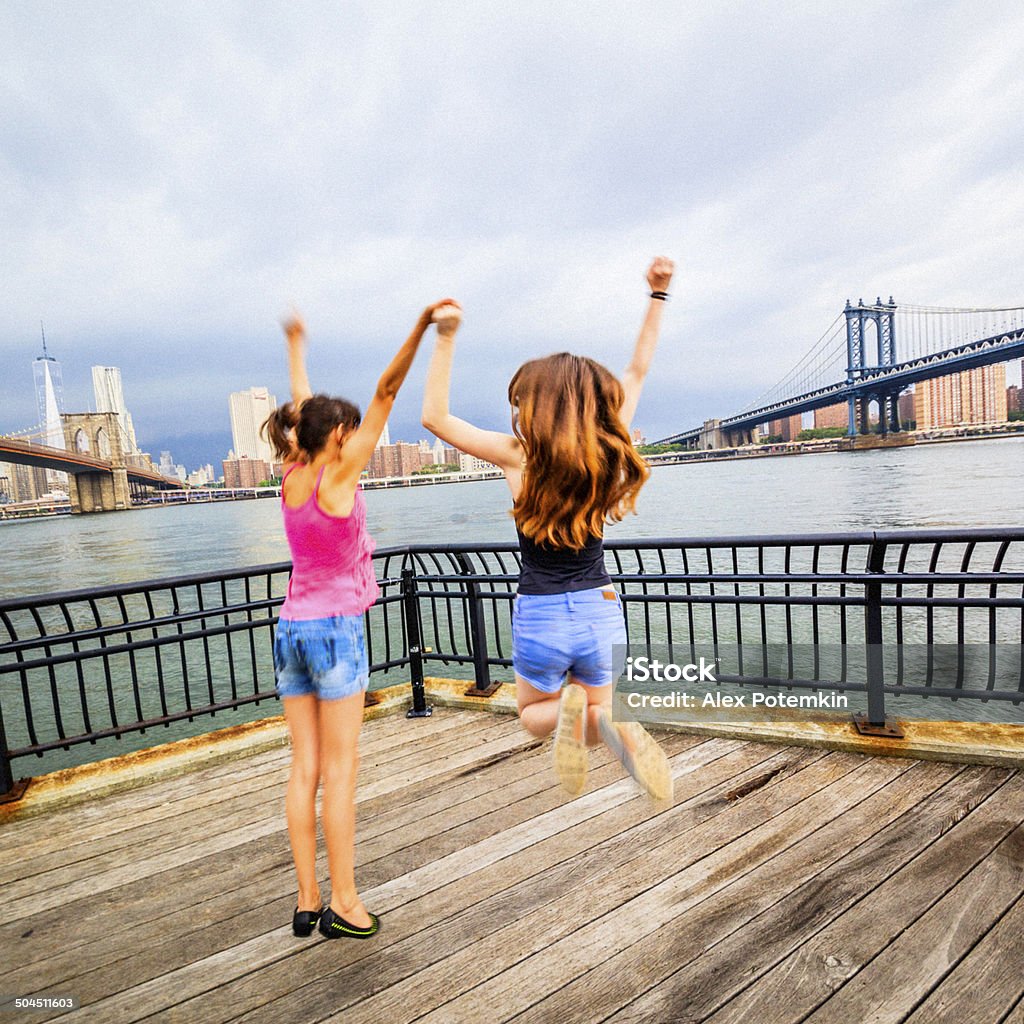 Dos niñas hermanas, saltar en el mar - Foto de stock de 12-13 años libre de derechos