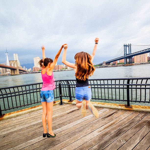 istock Two girls, sisters, jumping at the waterfront 504511603