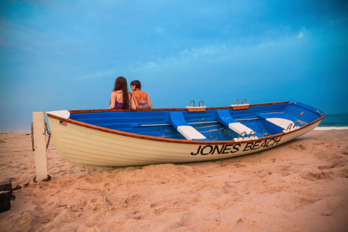 Two girls stay at the Jones Beach at the sunset