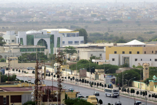 Nouakchott, Mauritania - July 19, 2014: traffic moving along Abdel Nasser Avenue with the Army HQ on the left and the Accounting School on the right