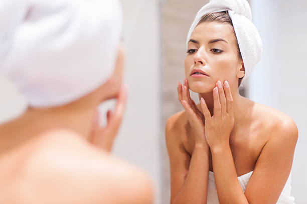 istock Woman looking on reflection in the mirror after shower 504512037