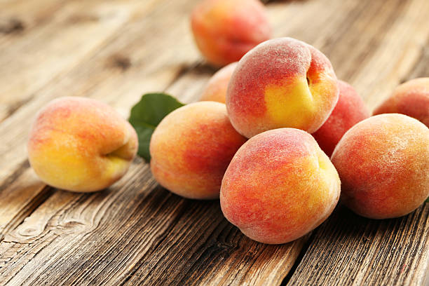 istock Ripe peaches fruit on a brown wooden background 504524186