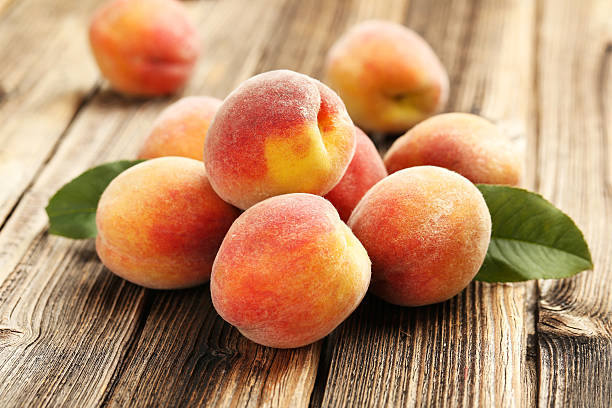 istock Ripe peaches fruit on a brown wooden background 504524486