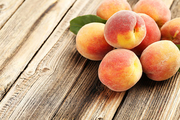 istock Ripe peaches fruit on a brown wooden background 504524886