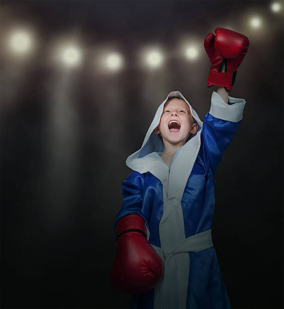 Happy vinner little boxer in ring lights Happy vinner little boxer in ring lights vinner stock pictures, royalty-free photos & images