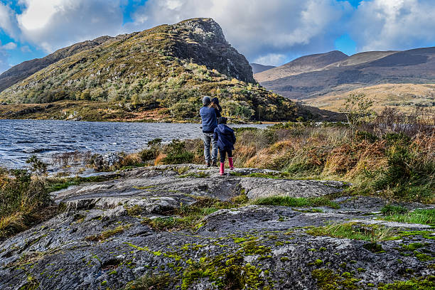 Explorers A family with a dad and young daughters looks out to an idyllic and incredible view in Killarney Ireland killarney lake stock pictures, royalty-free photos & images