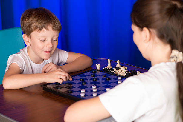 istock Children boy and girl playing a board game called Checkers 504527424