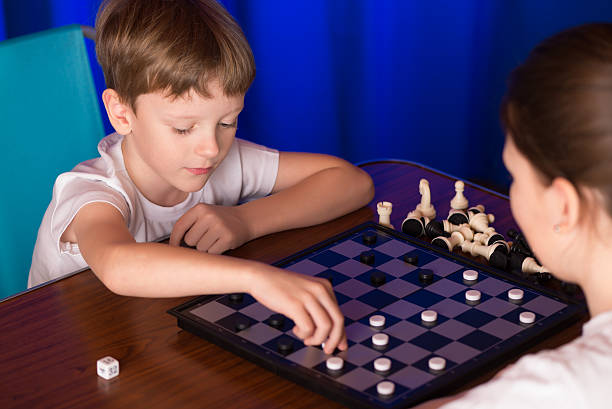 istock Children boy and girl playing a board game called Checkers 504527618