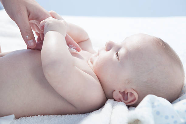 Mother applying cream over baby boy Mother applying cream over three months baby boy after bath creaming stock pictures, royalty-free photos & images