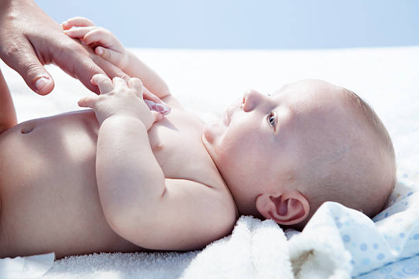 Mother applying cream over baby boy Mother applying cream over three months baby boy after bath creaming stock pictures, royalty-free photos & images