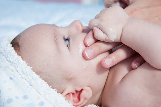 Mother applying cream over baby boy Mother applying cream over three months baby boy after bath creaming stock pictures, royalty-free photos & images