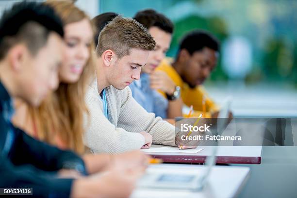 Working On A Homework Assignment Stock Photo - Download Image Now - Lecture Hall, Classroom, University