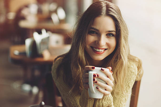 Charming girl drinking cappuccino and eating cheesecake stock photo