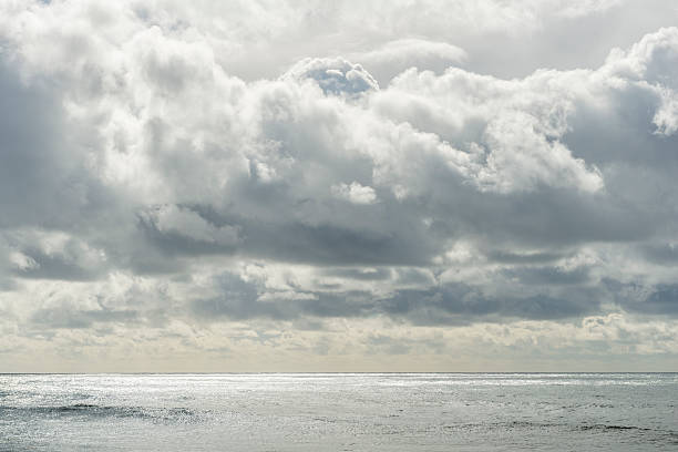 Sun through clouds illuminating reflected sea. Back lit.