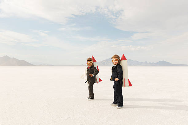 Young Business Boys Wearing Rockets Two young business boys dressed in business suits wearing rockets and aviator goggles are ready to launch their business into the sky. The boys are standing on the Bonneville Salt Flats in Utah, USA. rocketship photos stock pictures, royalty-free photos & images
