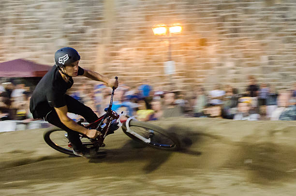 Panning of a cyclist Quebec, Canada - July 30, 2014: Panning of a cyclist riding on a curve made with sand in front of a crowd during a free and public outdoor competition downtown Quebec city. bmx racing stock pictures, royalty-free photos & images