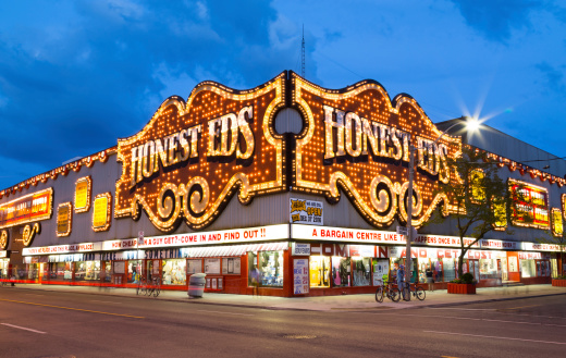 Toronto, Canada - July 30, 2014: The outside of the Honest Eds Store at night in Toronto. People can be seen outside the building.