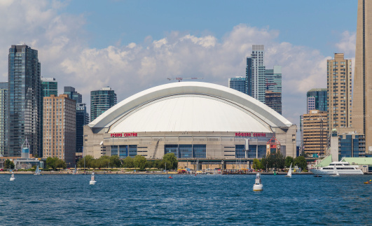 Toronto, Canada - July 27, 2014: The Rogers Centre from Lake Ontario during the day. Boats and people can be seen in the distance