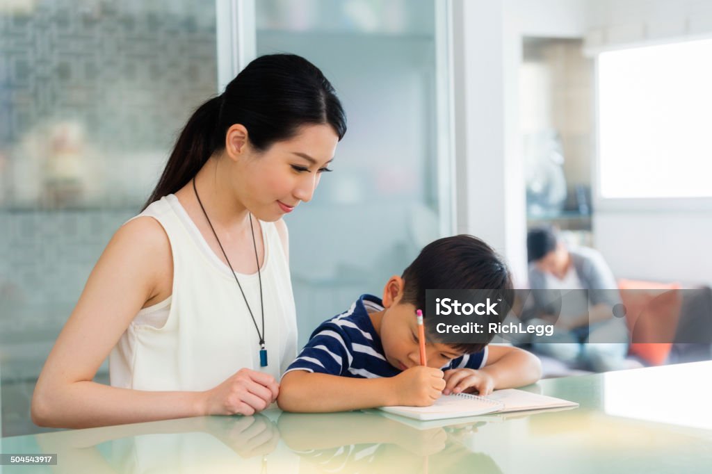 Chinese Schoolwork A Chinese woman and a little boy work on schoolwork. Asia Stock Photo